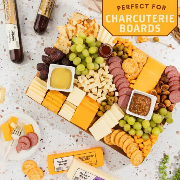 A cheese and cracker tray with crackers, grapes, nuts, and other snacks.